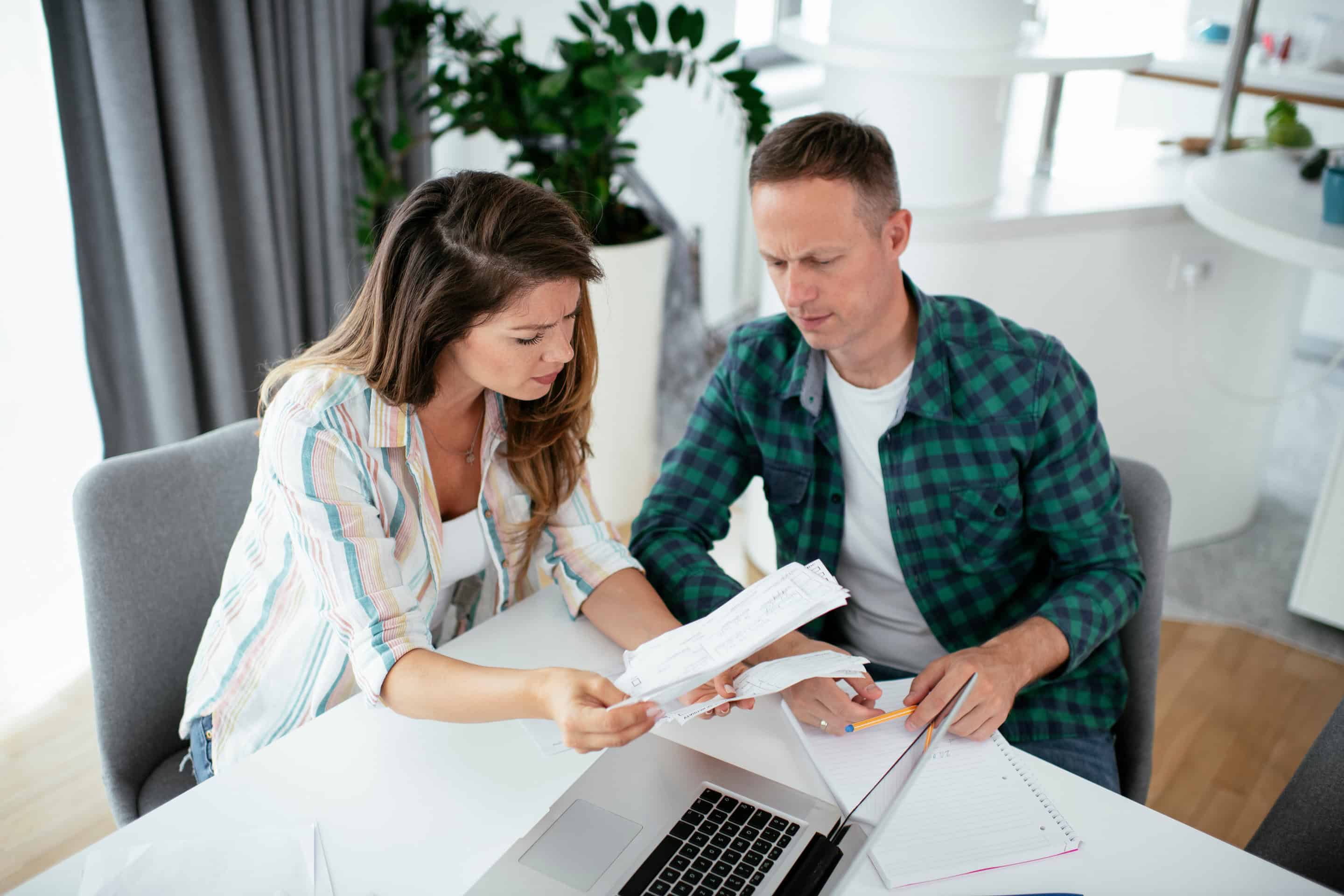 Man en vrouw kijken bedenkelijk bij het bekijken van de rentestijging.